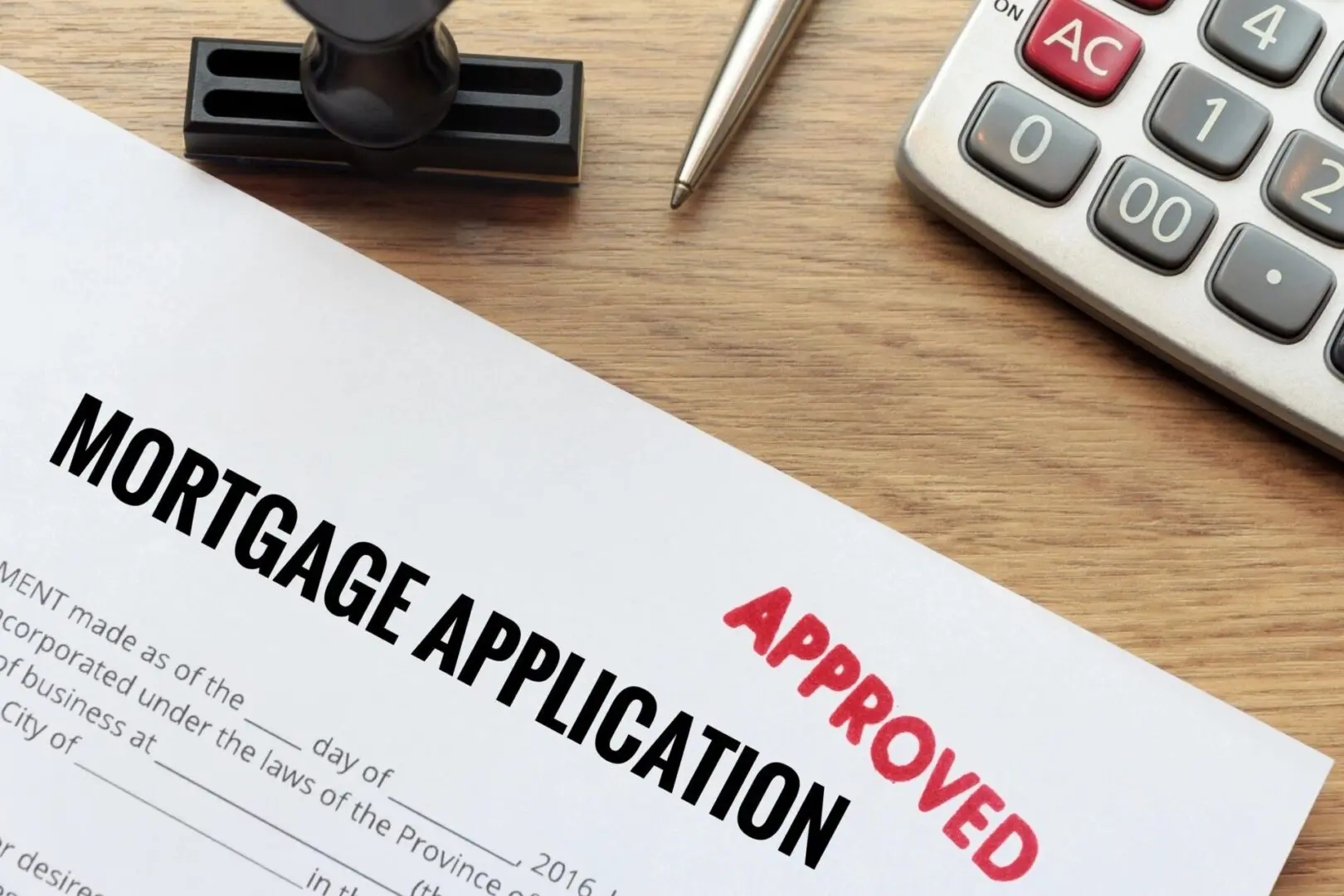 Approved Mortgage application form, lay down on wooden desk with pen and calculator