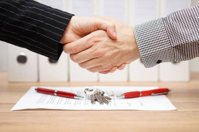 Client and agent are handshaking over real estate contract